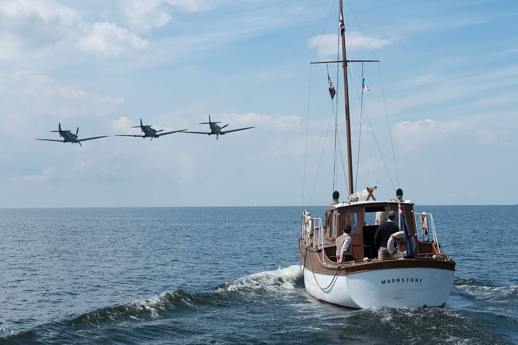 Three fighter planes approach a sail boat.