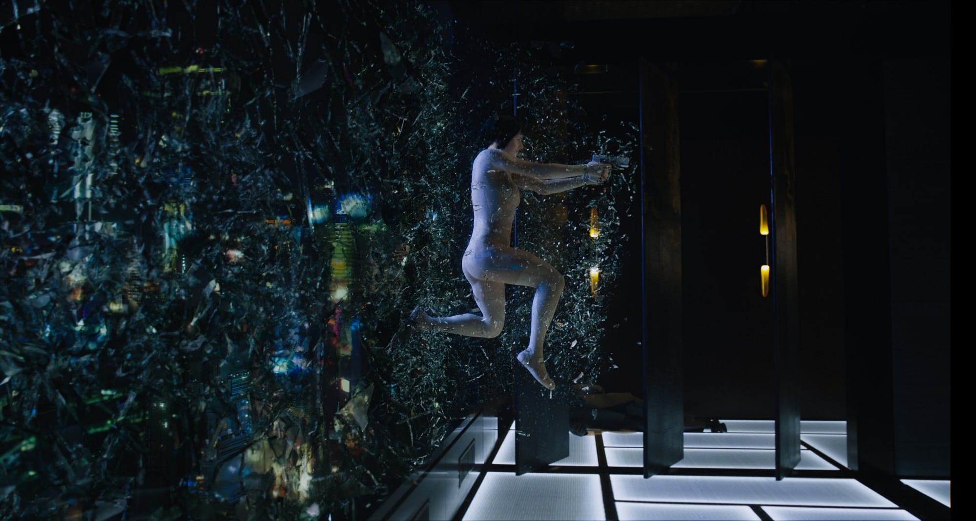 Scarlett Johansson jumps through a glass window shooting enemies