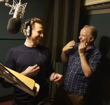 Two men laugh in the vocal booth.