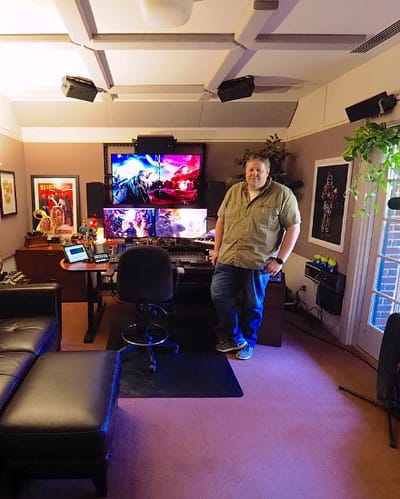 A man stands in his well designed sound studio.