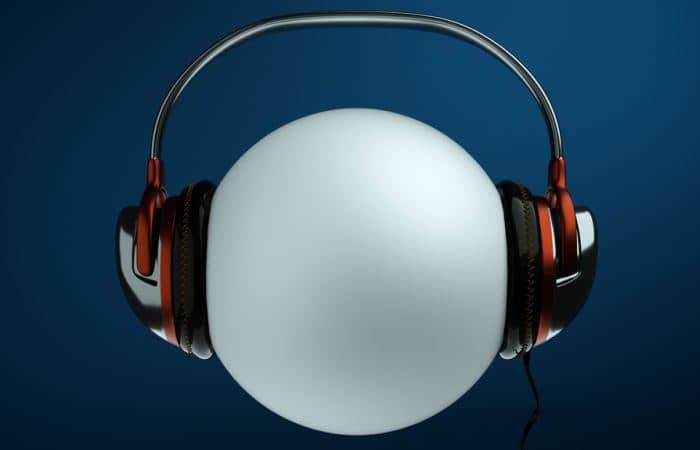 A white sphere wears over-the-ear headphones.