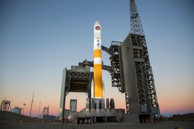 The orange and white rocket stands several stories high like a beacon in the night.