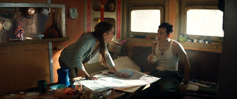 Lara and her shipmate debate over a handful of maps in their cabin.