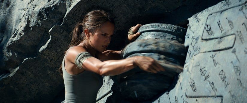 Lara Croft turns a stone to solve a tomb riddle.