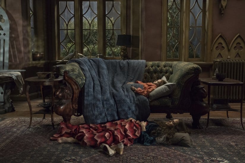 A young girl sleeps on a couch as her mother sleeps on the floor in the mansion's parlour.