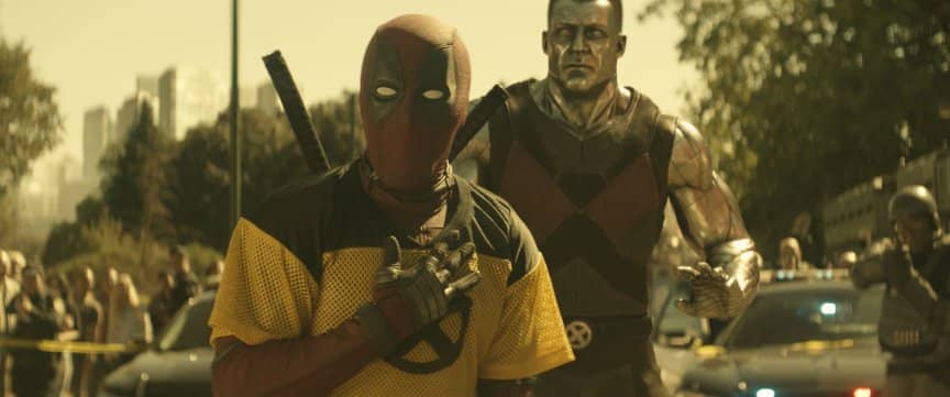 Deadpool and Colossus look shocked as they stand in a cordoned-off area.