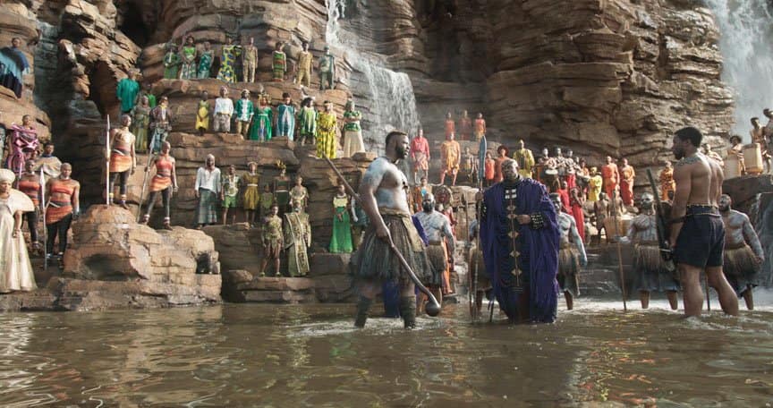 A warrior ceremony is held next to a waterfall