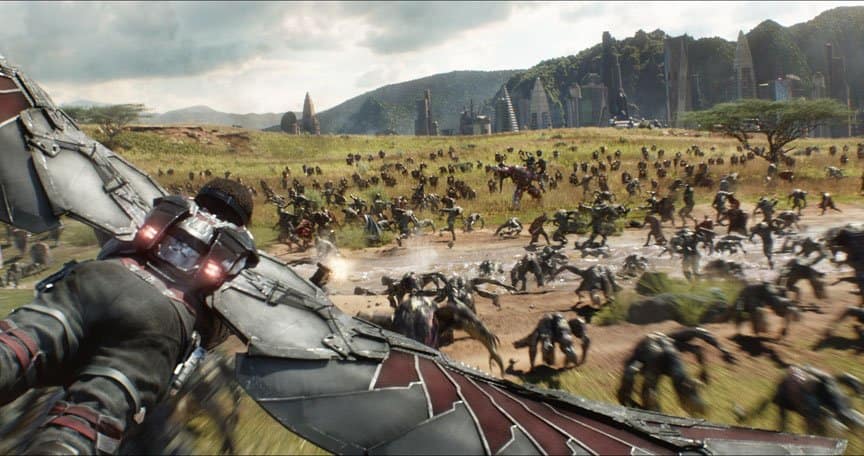 Falcon flies over a grassy battlefield in Wakanda.