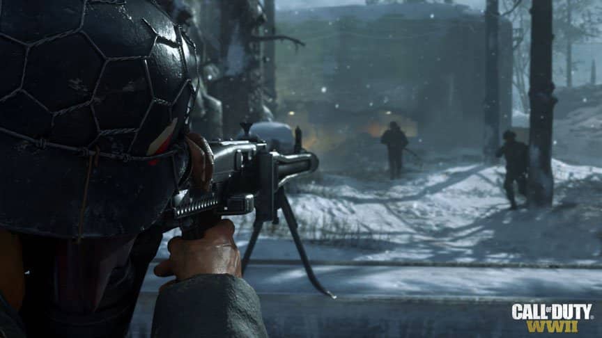A SAW gunner looks down his iron sights toward the silhouettes of two men.