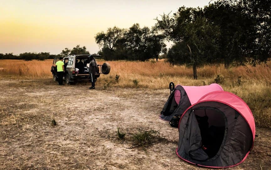 Men prepare tents near their Jeep.