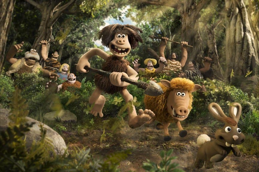 A tribe of cavemen, along with a boar and rabbit, smile and run.