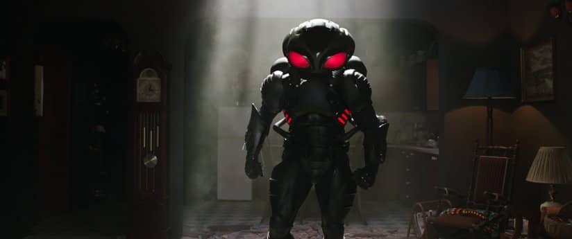 A dark metallic figure with a large head and red buggy eyes stands fiercely in small open kitchen.