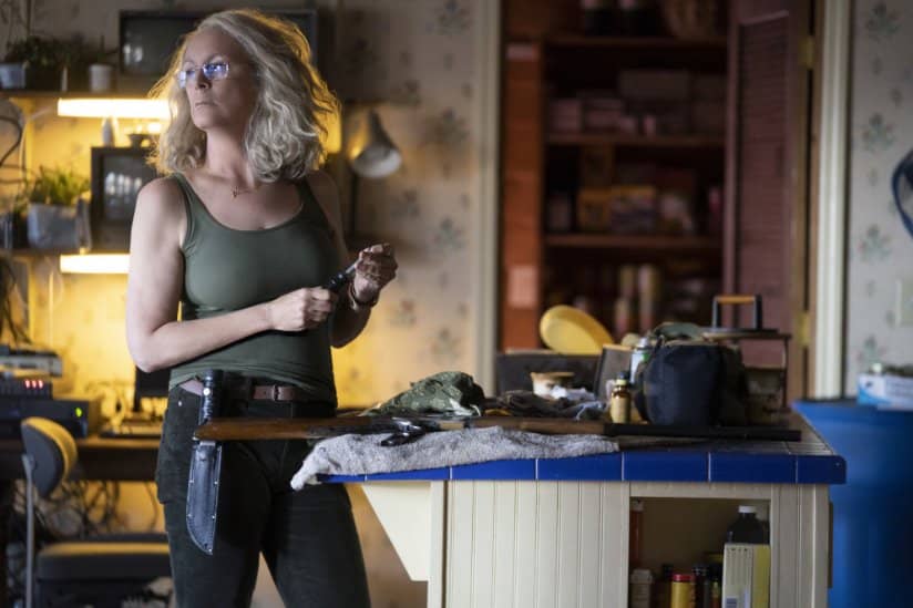 Jamie Lee Curtis looks off into the distance as she holds a screwdriver.