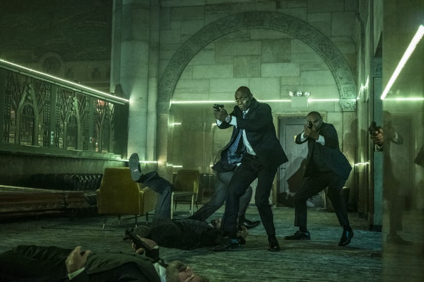Man in suits with guns enter Grand Central Station lined with bodies