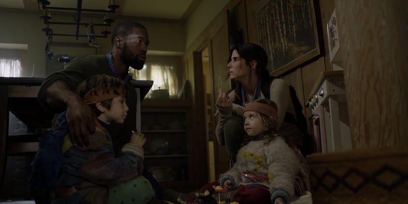 A concerned woman and man sit in a house with their children.