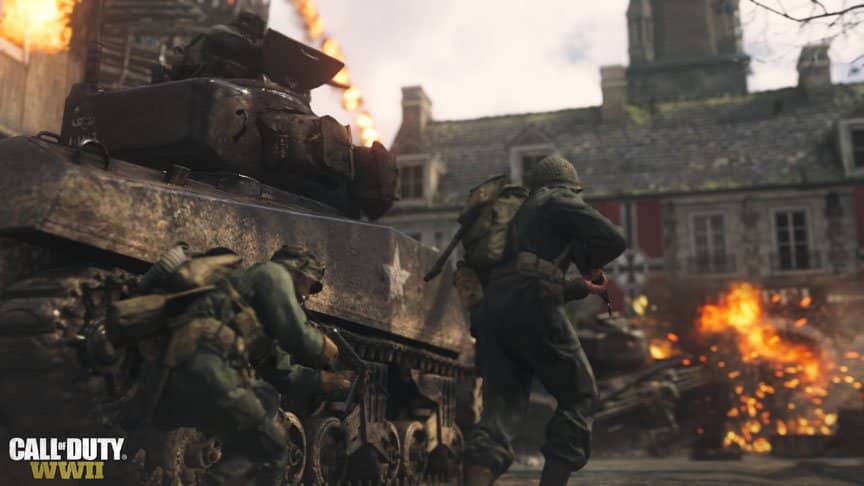 Two American soldiers use a tank as cover as they charge a Nazi base.