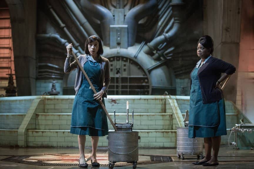 Two women stand in next to mop buckets